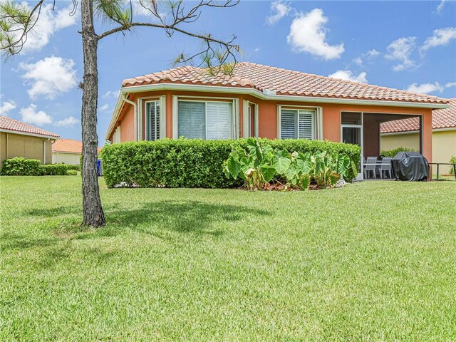 6243 Thames Pl, Vero Beach, FL 32966 - view of front of home with a tile roof, a front yard, and stucco siding