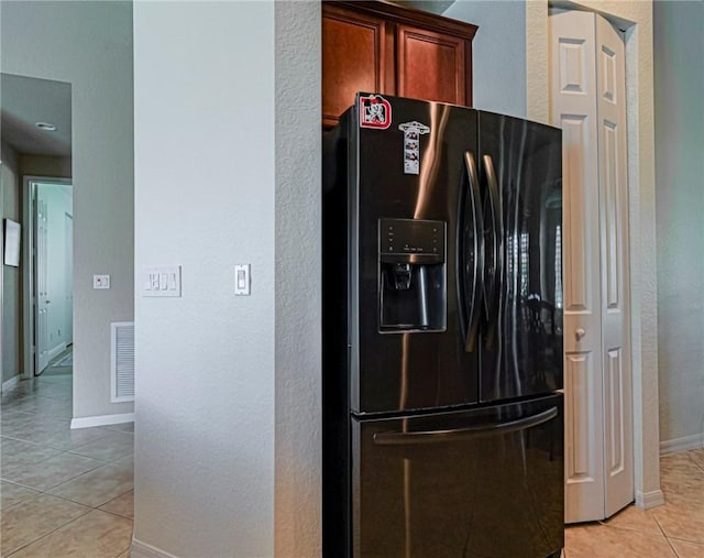 6243 Thames Pl, Vero Beach, FL 32966 - kitchen featuring black refrigerator with ice dispenser, light tile patterned floors, and a textured wall