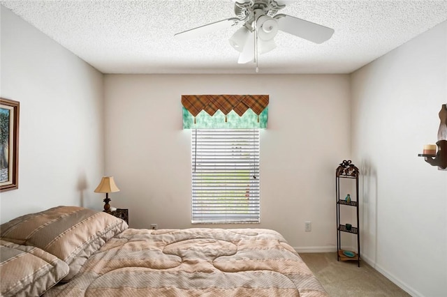 carpeted bedroom with ceiling fan and a textured ceiling