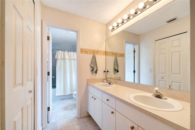 bathroom featuring walk in shower, vanity, toilet, and a textured ceiling