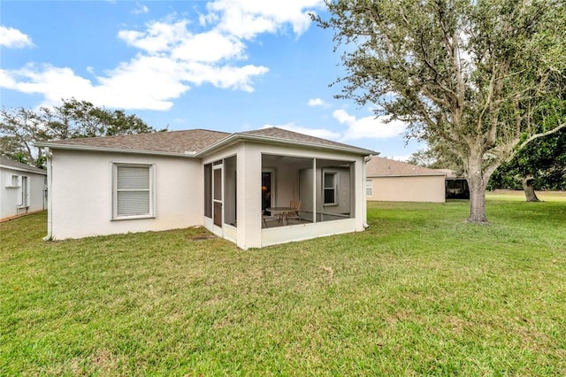 back of property featuring a sunroom and a lawn