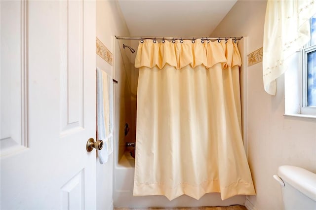 bathroom with shower / tub combo with curtain and toilet