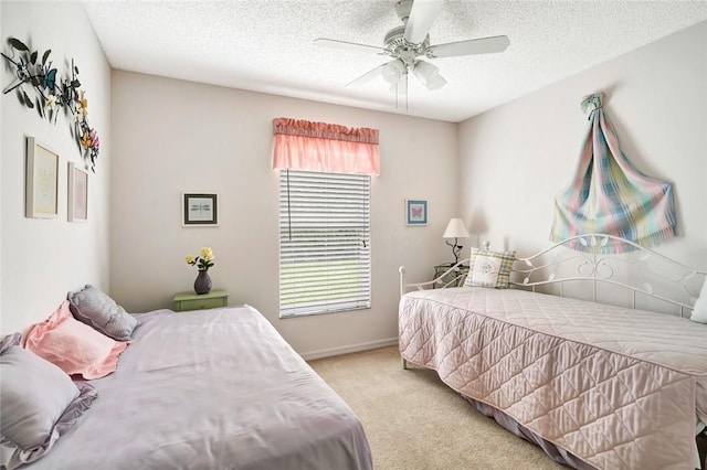 bedroom featuring light carpet, a textured ceiling, and ceiling fan