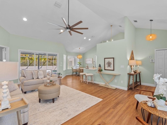 living room with high vaulted ceiling, light hardwood / wood-style flooring, and ceiling fan