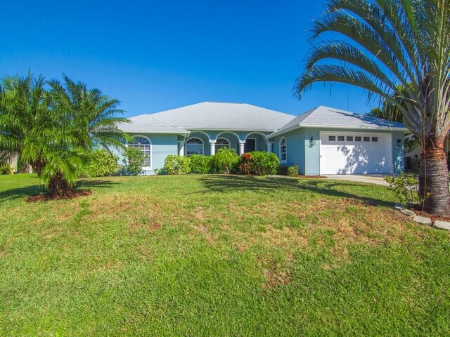 ranch-style house with a garage and a front lawn