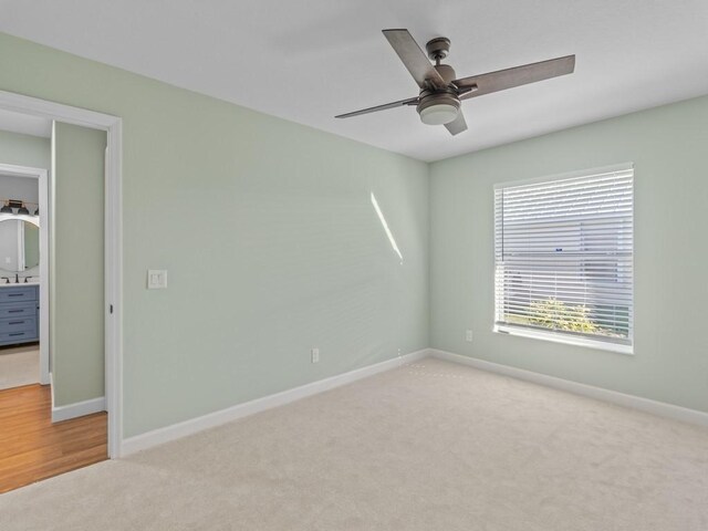 carpeted empty room featuring ceiling fan