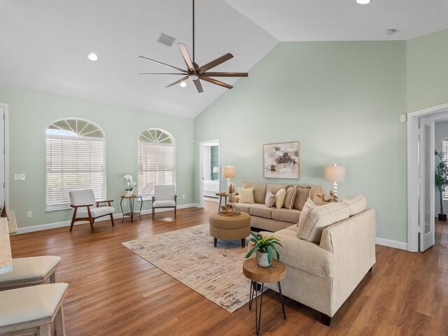 living room featuring hardwood / wood-style flooring, ceiling fan, and high vaulted ceiling