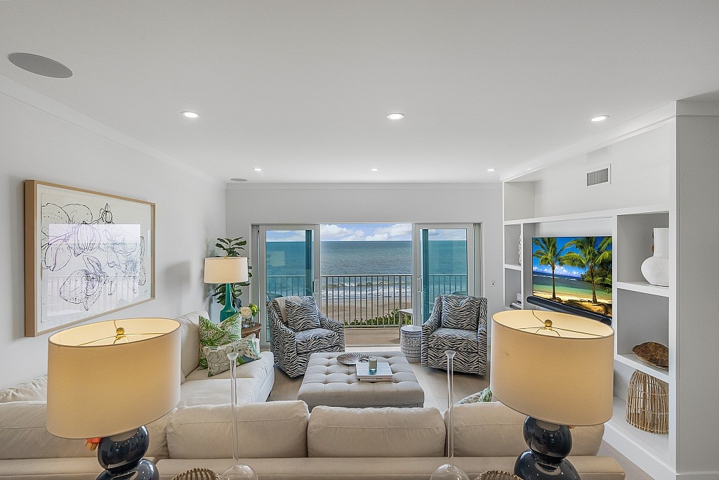 living room featuring light hardwood / wood-style floors, a water view, and ornamental molding