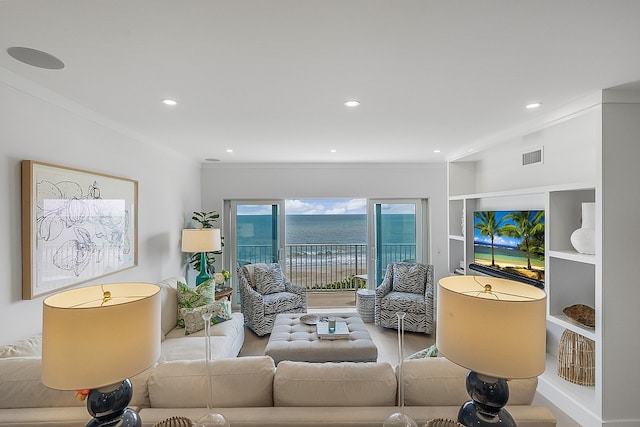 living room featuring light hardwood / wood-style floors, a water view, and ornamental molding