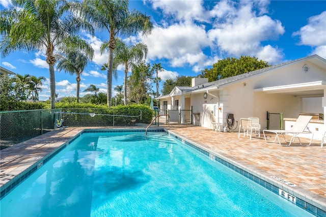 pool with a patio and fence