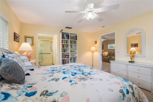 carpeted bedroom with visible vents, connected bathroom, and a ceiling fan