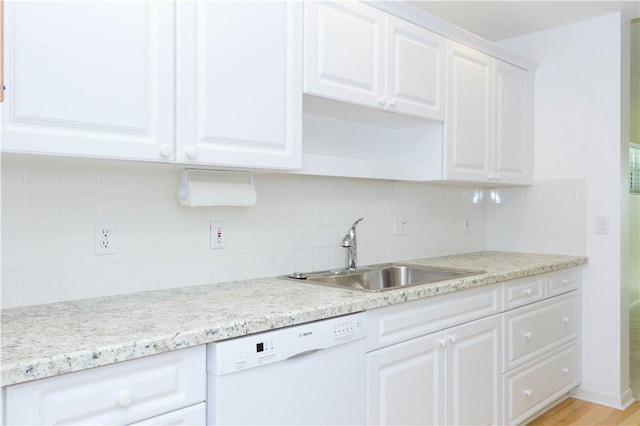 kitchen with dishwasher, white cabinets, tasteful backsplash, and a sink