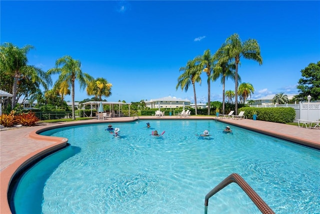 community pool with a patio and fence