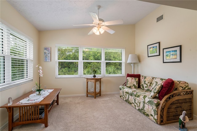 living room featuring visible vents, a textured ceiling, carpet floors, baseboards, and vaulted ceiling