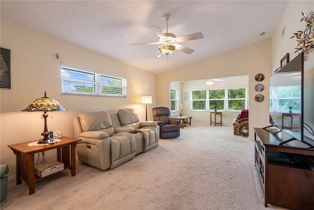 living room featuring ceiling fan, a healthy amount of sunlight, lofted ceiling, and light carpet