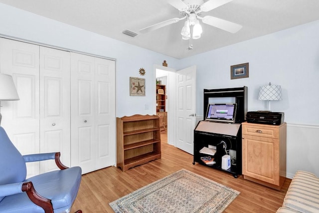 sitting room featuring visible vents, light wood finished floors, baseboards, and a ceiling fan
