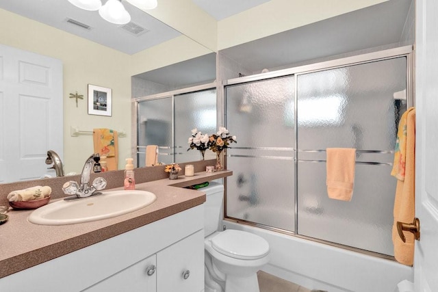 full bath featuring shower / bath combination with glass door, visible vents, toilet, and vanity