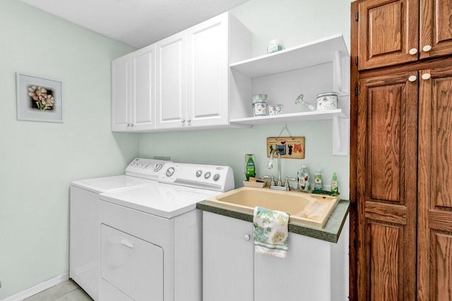 clothes washing area with a sink, independent washer and dryer, and cabinet space
