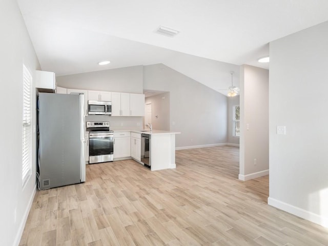 kitchen with light hardwood / wood-style flooring, appliances with stainless steel finishes, kitchen peninsula, ceiling fan, and white cabinets