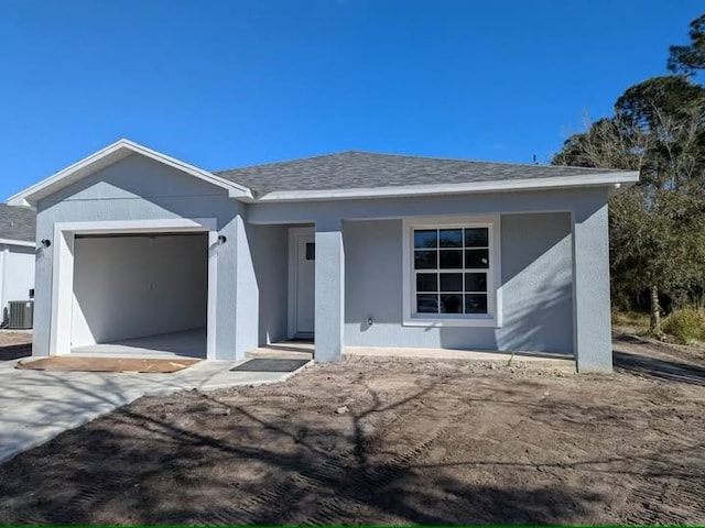 ranch-style house featuring a garage and central AC