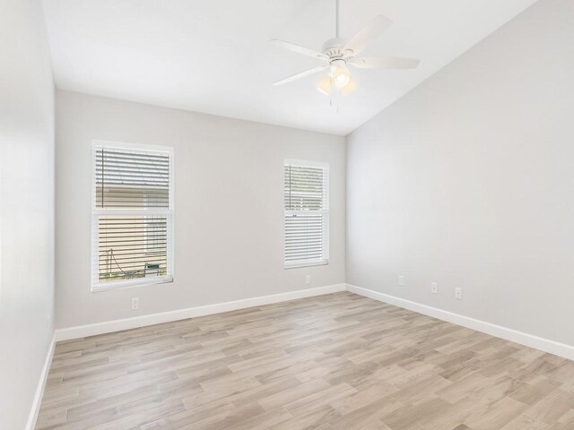 empty room with light hardwood / wood-style flooring, ceiling fan, and vaulted ceiling