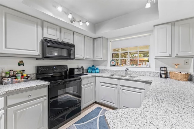 881 Foster Ave, Sebastian, FL 32958 - kitchen with black appliances, white cabinetry, light tile patterned flooring, and light stone countertops