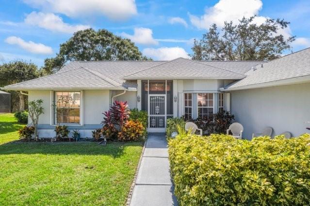 881 Foster Ave, Sebastian, FL 32958 - ranch-style house with stucco siding, a front lawn, and a shingled roof