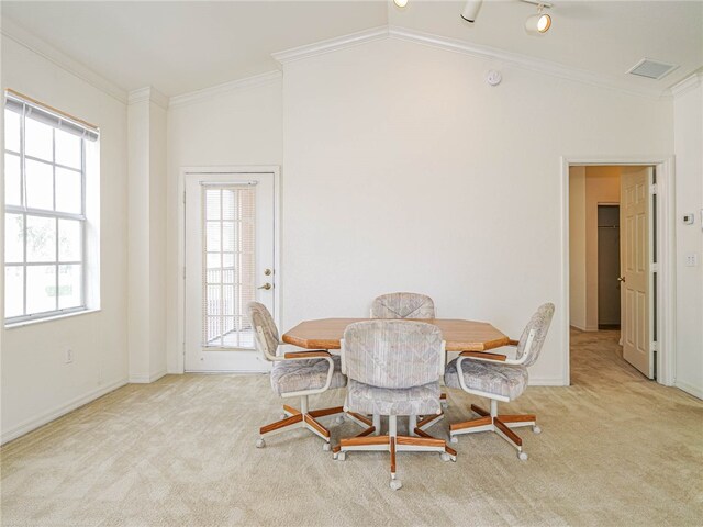 dining room with ornamental molding, vaulted ceiling, and light carpet