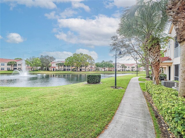 view of home's community featuring a water view and a yard