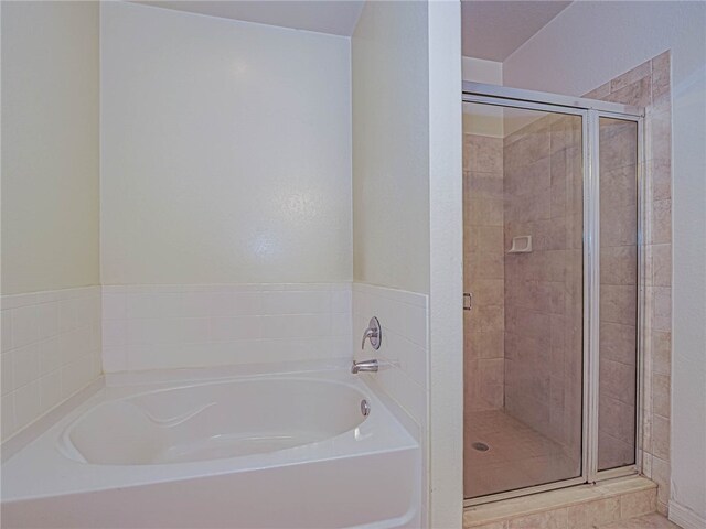 bathroom featuring separate shower and tub