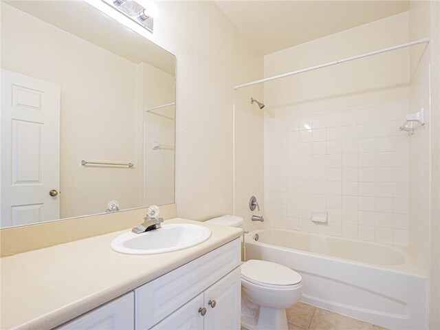 full bathroom featuring vanity, toilet, tiled shower / bath combo, and tile patterned flooring