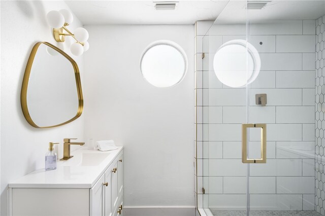 bathroom with a shower with shower door and vanity