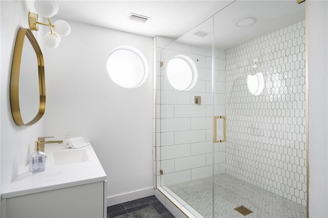 bathroom with tile patterned floors, a shower with shower door, and vanity