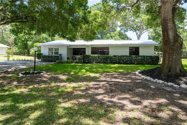 single story home featuring a front lawn