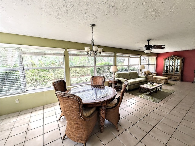 sunroom featuring ceiling fan with notable chandelier