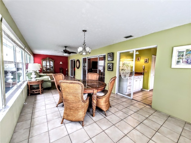 dining room with ceiling fan with notable chandelier and light tile patterned floors