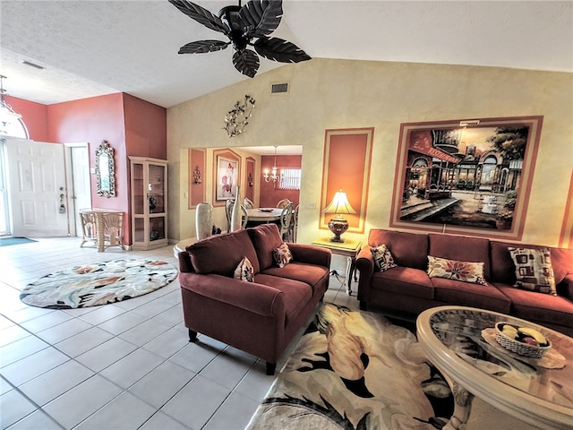 tiled living room with a healthy amount of sunlight, ceiling fan with notable chandelier, and vaulted ceiling