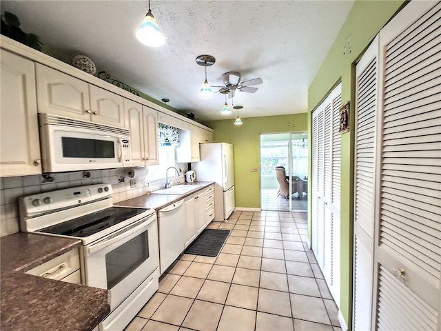 kitchen with white appliances, tasteful backsplash, sink, decorative light fixtures, and light tile patterned flooring