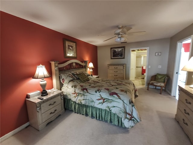 bedroom with light colored carpet, connected bathroom, and ceiling fan