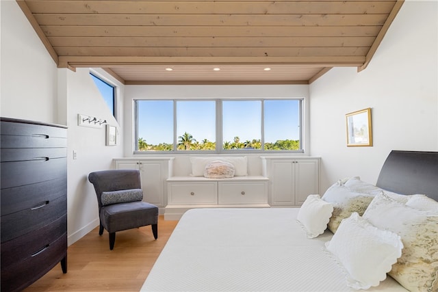 bedroom featuring light hardwood / wood-style floors, wood ceiling, and multiple windows