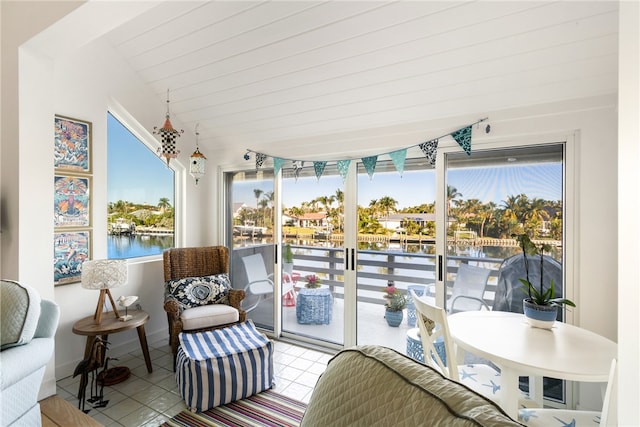 sunroom / solarium with a water view and a healthy amount of sunlight