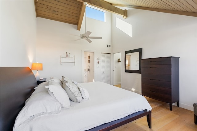 bedroom featuring beam ceiling, ceiling fan, light hardwood / wood-style flooring, a closet, and wood ceiling