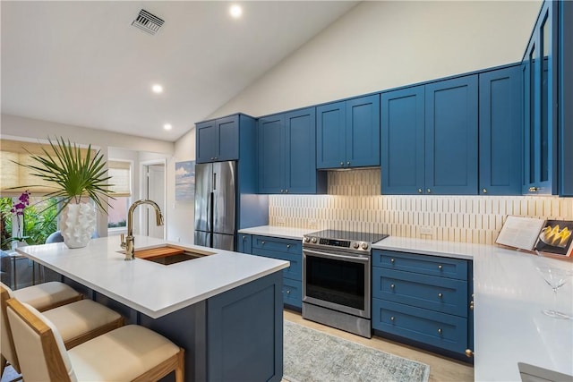 kitchen with a kitchen bar, sink, stainless steel appliances, a center island with sink, and lofted ceiling