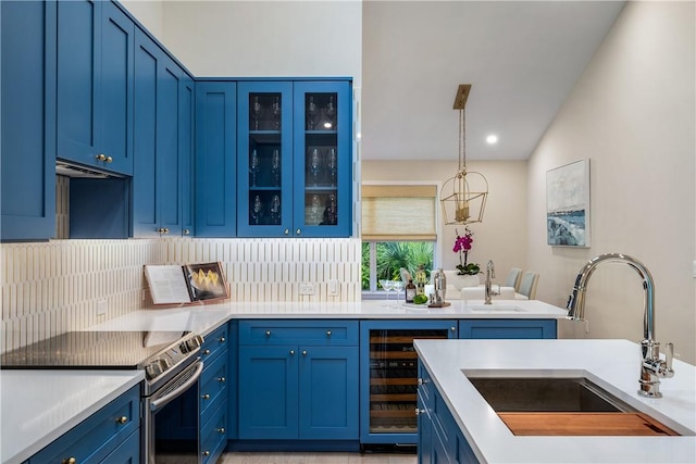 kitchen with sink, blue cabinetry, and stainless steel range with electric stovetop