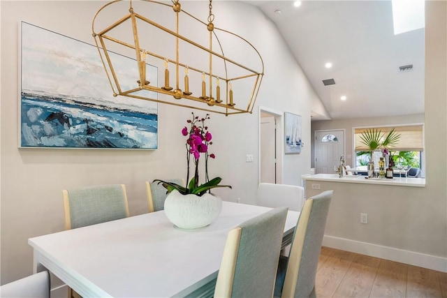 dining room featuring light hardwood / wood-style flooring and vaulted ceiling