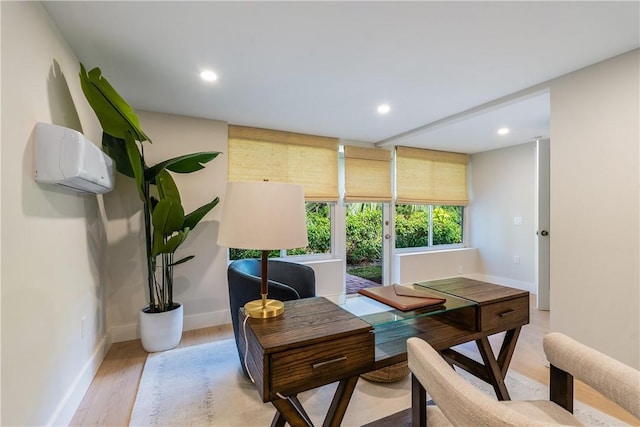 office area featuring light hardwood / wood-style floors and a wall unit AC