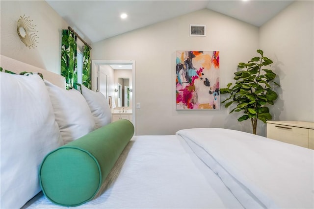 bedroom featuring ensuite bath and vaulted ceiling