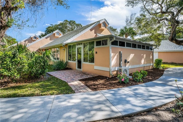 view of front facade with a patio, ac unit, and a sunroom