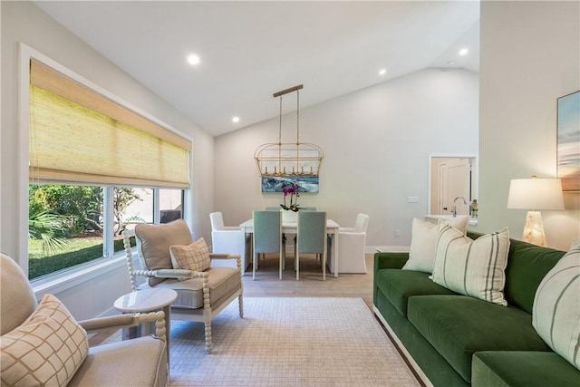 living room with lofted ceiling and an inviting chandelier