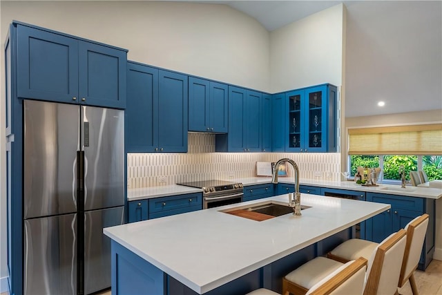 kitchen featuring a breakfast bar area, an island with sink, appliances with stainless steel finishes, and sink